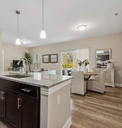 A kitchen with a black counter top and brown cabinets.