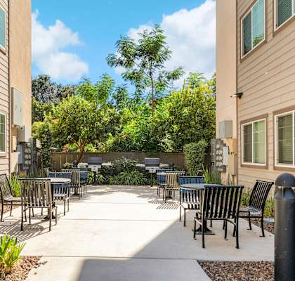 A patio area with chairs and tables surrounded by buildings.
