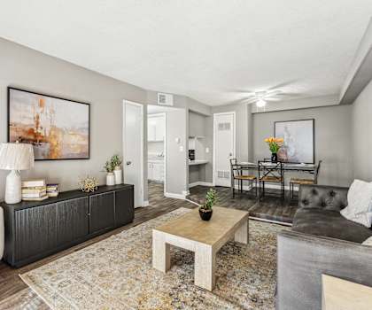 A living room with a white couch, a coffee table, and a painting on the wall.