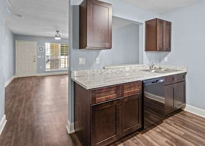 an empty kitchen with wooden floors and a counter top with a sink