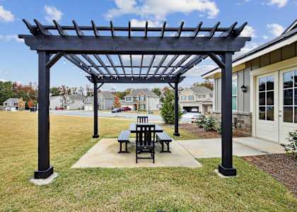 a patio with a table and chairs under a pergola