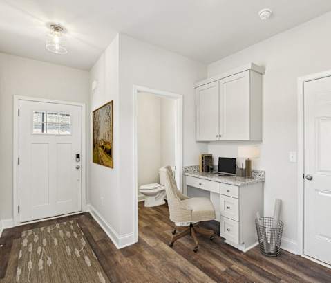 a room with a desk and a chair and a toilet