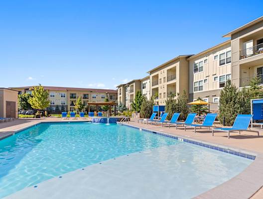 our apartments have a large swimming pool with blue lounge chairs