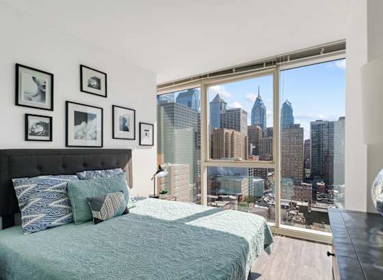 a bedroom with a bed and a large window