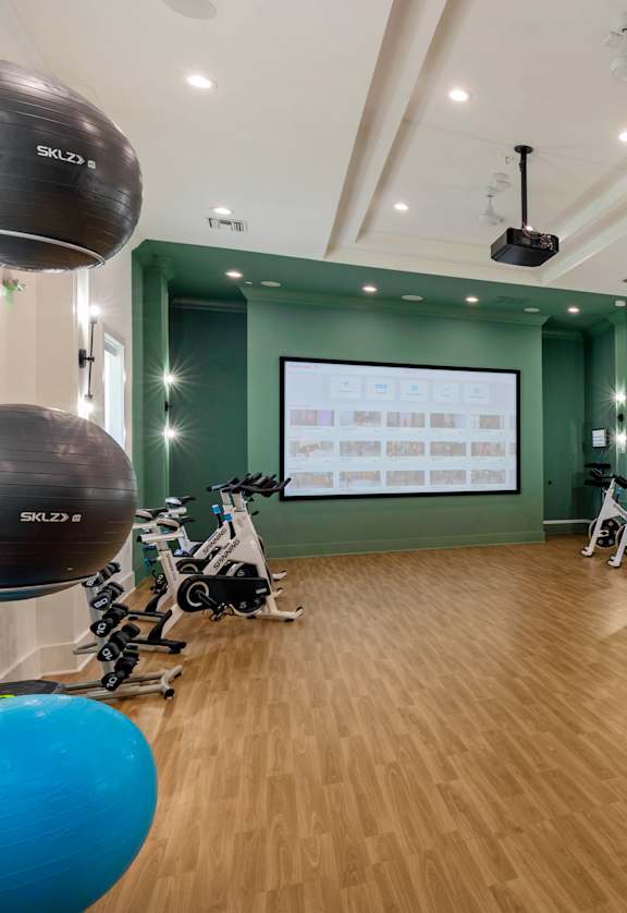 a large room with green walls and hardwood floors and a projector screen on the wall