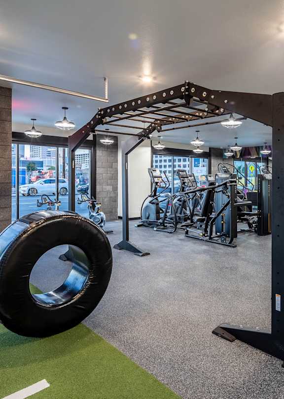 A gym with a green floor mat and a tire on it.