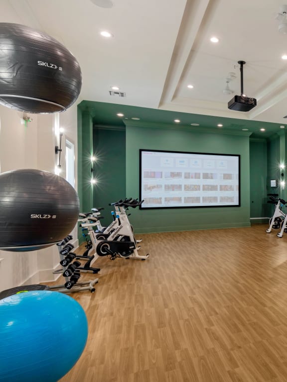 a large room with green walls and hardwood floors and a projector screen on the wall