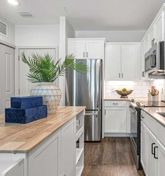 a kitchen with stainless steel appliances and a counter top with three stools at Casa Marti, Tampa, 33605
