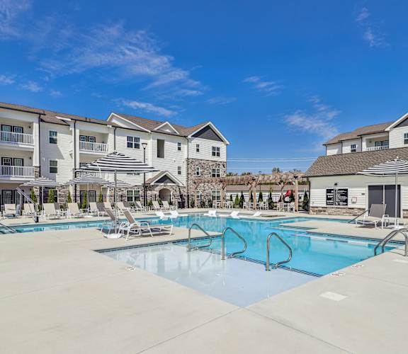 our apartments have a large pool with chairs and umbrellas