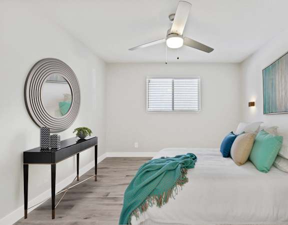 a bedroom with a large bed and a ceiling fan