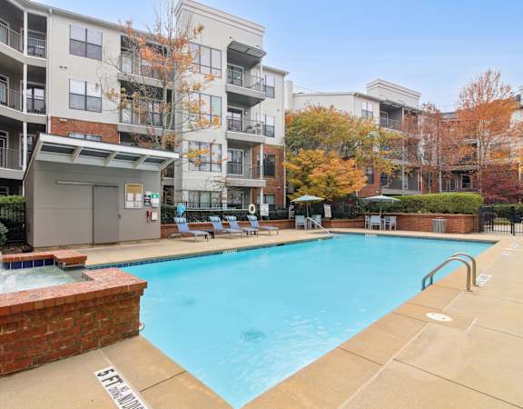 A large swimming pool in front of apartment buildings.