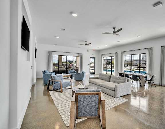 a living room with a couch and a table with chairs and a pool