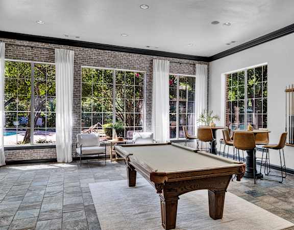a game room with a pool table and windows
