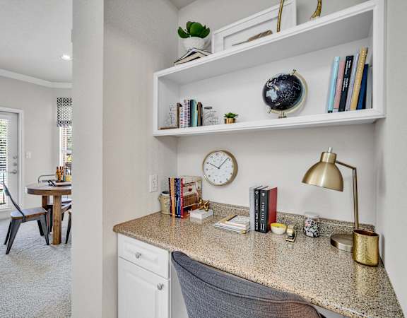 a home office with a desk and a clock on a shelf