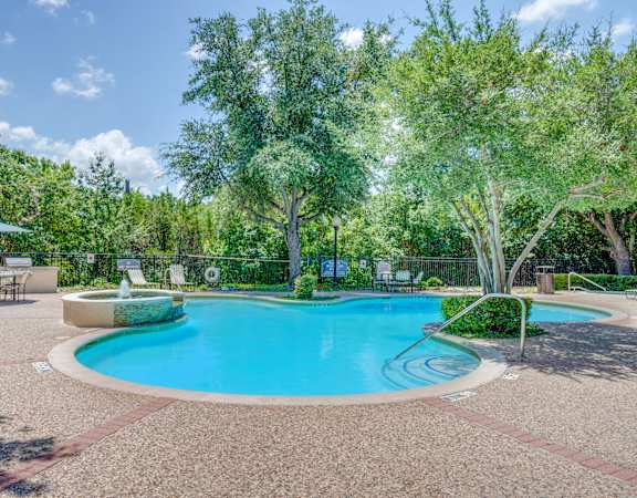 a swimming pool with trees and a fence around it