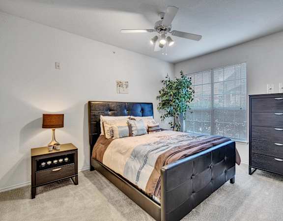 a bedroom with a large bed and a ceiling fan
