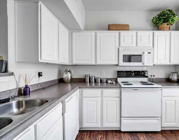 a kitchen with white cabinets and appliances and a sink