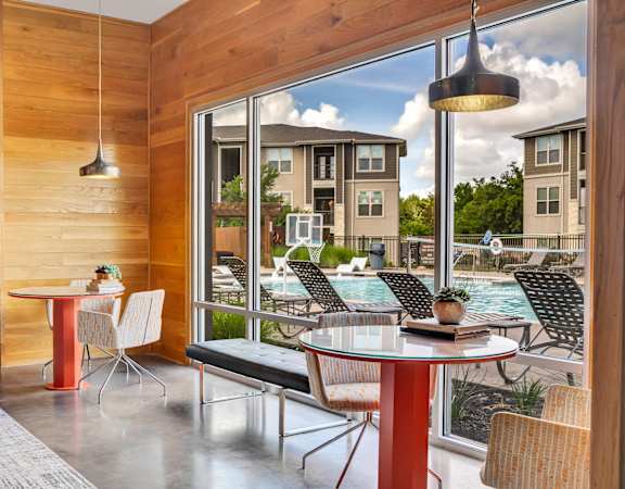 a dining area with tables and chairs next to a pool