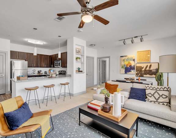 a living room and kitchen with a ceiling fan