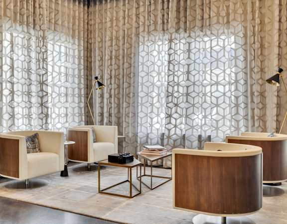 a lobby with chairs and tables and a curtain