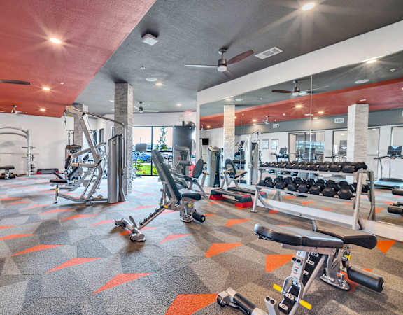 a gym with weights and cardio equipment at the apartments