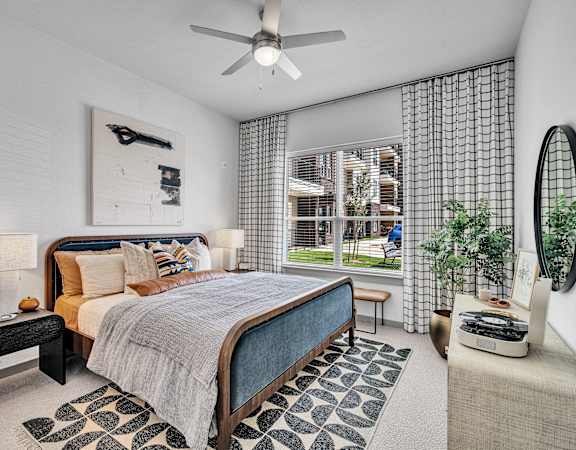 a bedroom with a bed and a ceiling fan