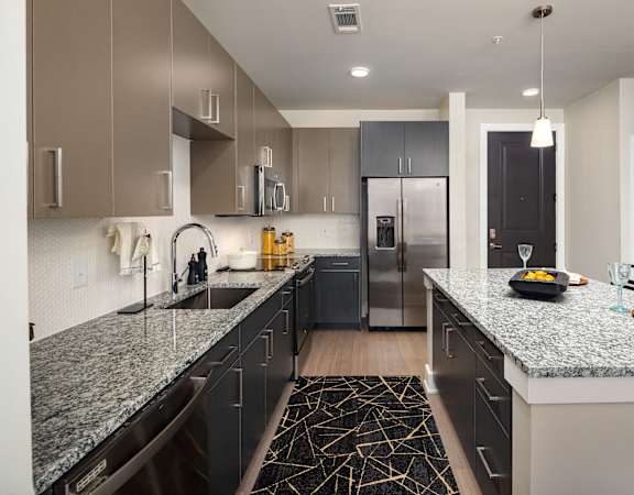a large kitchen with granite counter tops and stainless steel appliances