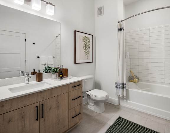 A bathroom with a white tub, sink, and toilet.