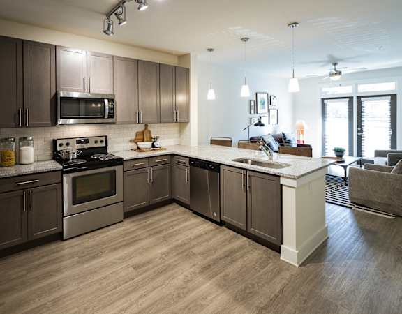 a large kitchen with stainless steel appliances and wooden cabinets