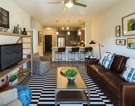 a living room with a checkered rug and a leather couch