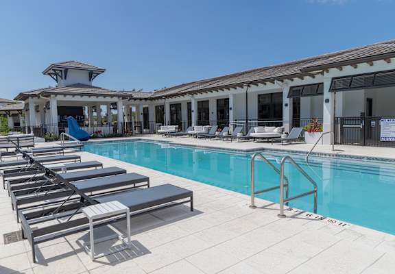 A poolside area with sun loungers and a pavilion.