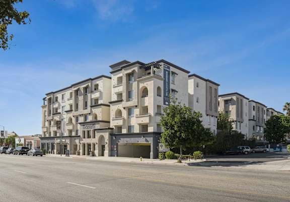 a large apartment building on the corner of a city street