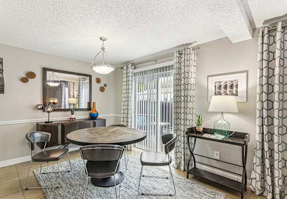 A living room with a round table and chairs.