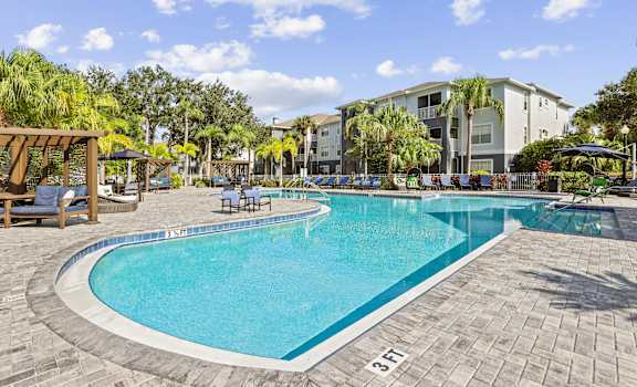 a large swimming pool with a hotel in the background