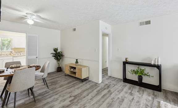 a living room and dining room with a table and chairs