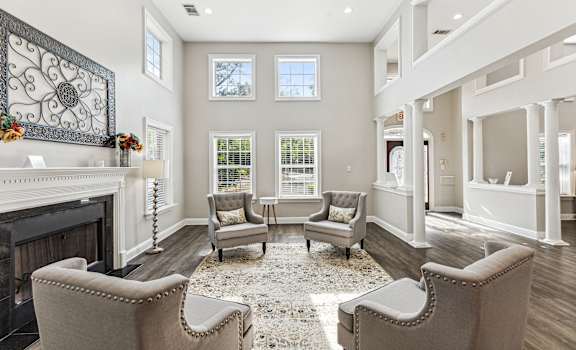 a living room with chairs and a fireplace
