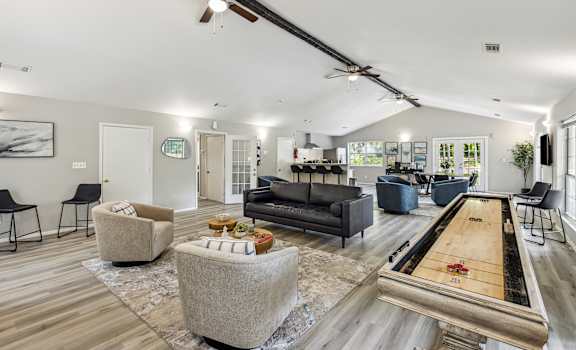 a living room with couches and chairs and a shuffleboard table