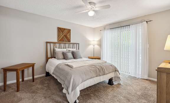 a bedroom with a bed and a ceiling fan