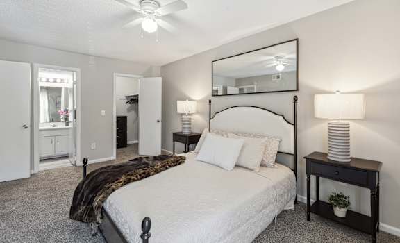 a bedroom with a bed and a ceiling fan