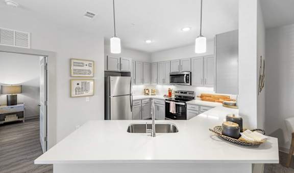 a kitchen with white countertops and stainless steel appliances