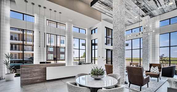 a living room with large windows and a table and chairs