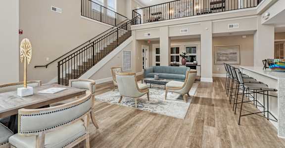 A large, well-lit living room with a staircase and a dining area.