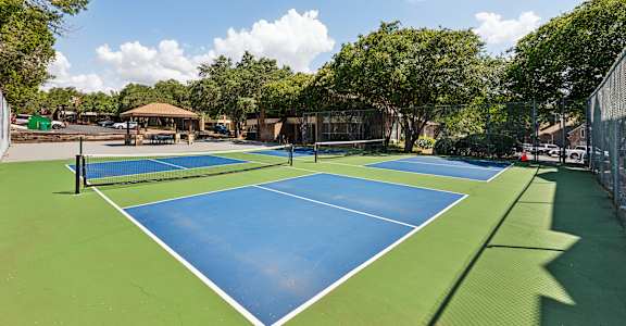 a pickleball court with two blue and green tennis courts