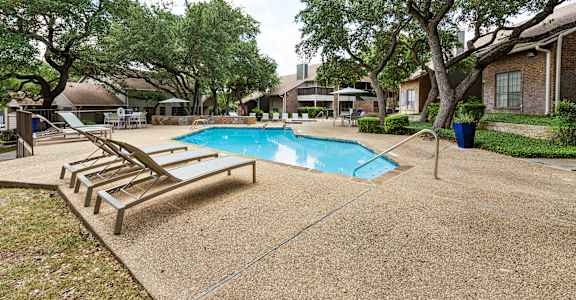 Carmel at Deerfield pool with lounge chairs and trees