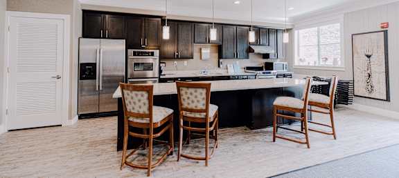 a kitchen with a large island with a bar and chairs