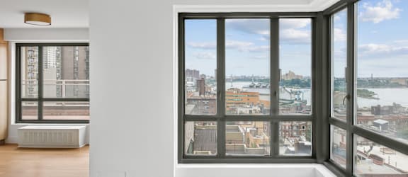 A room with a large window overlooking a cityscape.