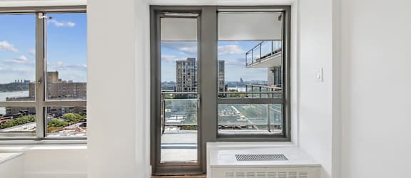 A room with a window and a view of a cityscape.