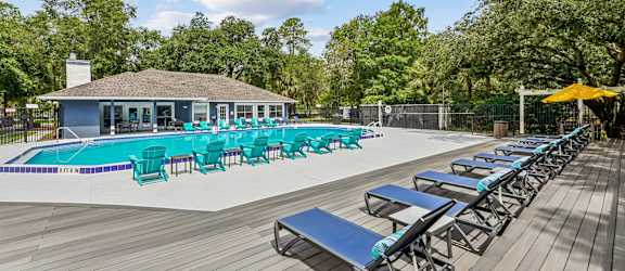 A poolside area with sun loungers and a building in the background.