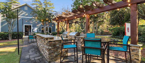 A patio with a table and chairs under a pergola.