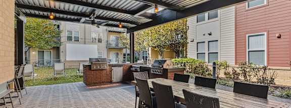 A patio with a table and chairs under a roof.
